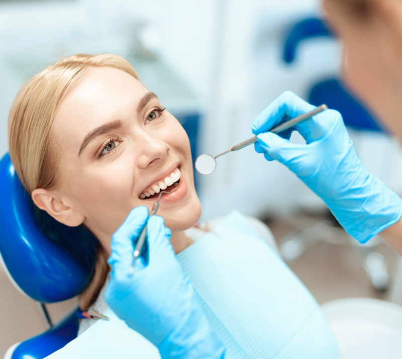 Hygienist cleaning patient’s teeth